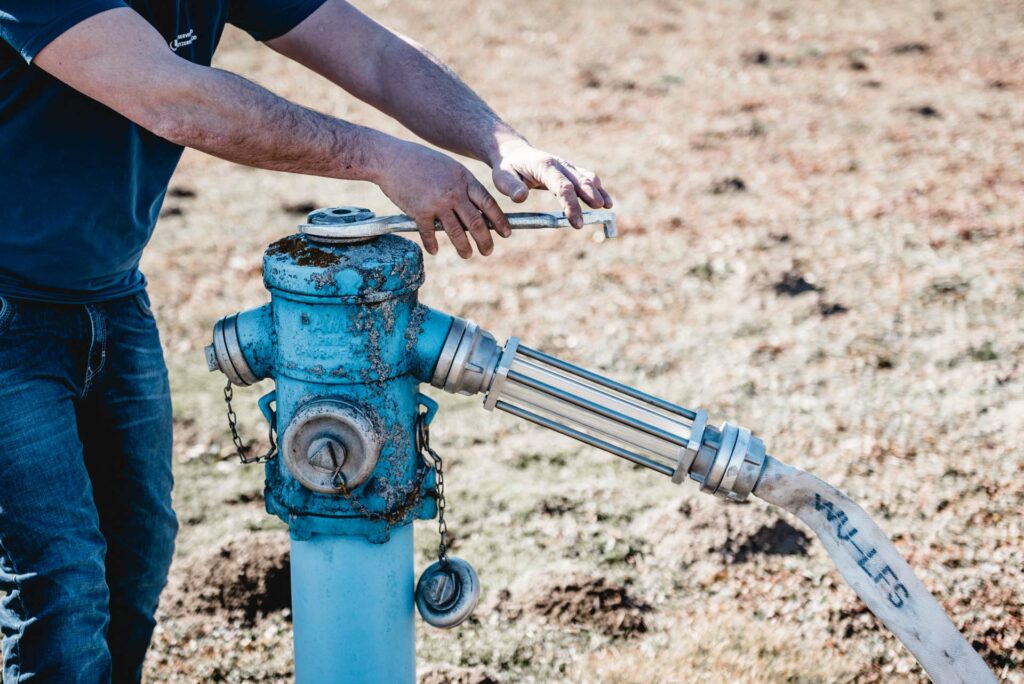 Techniker dreht am Wasserhydranten
